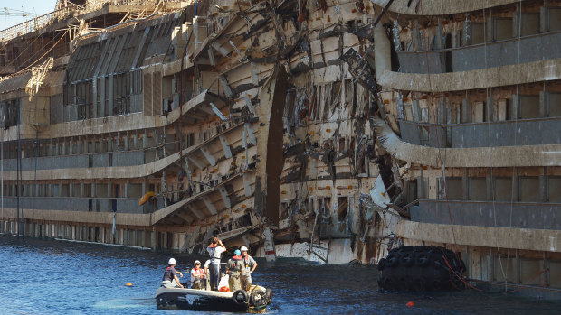 Salvage workers inspect the wreck of Italy's Costa Concordia cruise ship after it was righted.