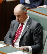 Liberal MP Stuart Robert takes his seat after denying any wrongdoing.