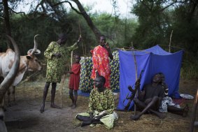 Some clan members from the cattle camps in Ciebet County sleep under nets, while others must rely of burning cow dung to ward off mosquitoes. A gun is always close by. Lakes State, South Sudan, 2014.
