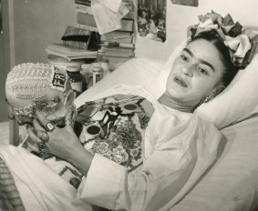 Frida Kahlo in hospital bed holding decorated skull, c1950s, gelatin silver print, 20.3 x 25.4 cm. Courtesy of Throckmorton Fine Art, Inc, Juan Guzman.