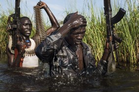 South Sudanese Nuer rebel soldiers patrol through a flooded area near the town of Bentiu. Unity State, South Sudan, 2014.