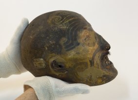 An employee displays a 19th century mummified Maori head conserved in the reserve collection of the Musee des Confluences.