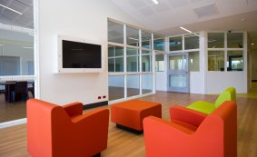 A lounge in the "Cassia" wing of the new secure mental health facility, with television secured in glass, safe furniture and a staff viewing room at the rear.