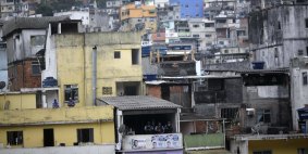Policemen stand on the veranda of a house during the inauguration of the Pacification Program (UPP) in the Rocinha favela in Rio de Janeiro in September 2012.  