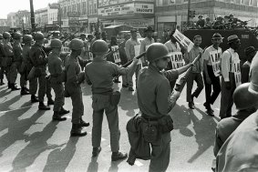 Striking sanitation workers walk past Tennessee National Guard troops armed with bayonets during a 20-block march to Memphis City Hall on March 29, 1968. (King was assassinated days later, on April 4, while in Memphis supporting the strike.)