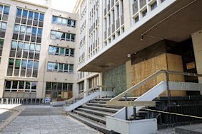 The building's main entrance is boarded up.