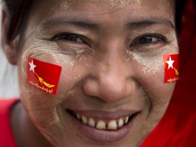 A member of Myanmar opposition leader Aung San Suu Kyi's National League for Democracy party smiles as she rides a trishaw during an election rally through a suburb in Yangon, Myanmar, on Tuesday.