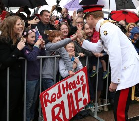 Prince Harry, one of the best known modern-day redheads shares a high five with Ethan Toscan, 12, from Bruce. 
