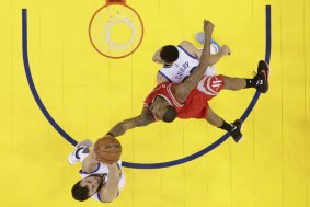 Tough in the paint: Houston Rockets forward Trevor Ariza battles for a rebound against Golden State Warriors duo Andrew Bogut and Stephen Curry.