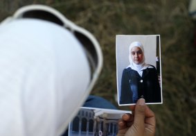 Wafaa Bukai, 25, a student from Damascus, Syria, holds a photograph as she waits for her brother to cross the border from Horgos, Serbia to Hungary. 