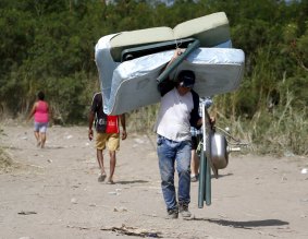 A man carries a mattress after crossing the Tachira River border on foot into Colombia from Venezuela this week. 