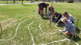 A group of Yass artists trial their labyrinth design with flour.