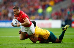 Around the legs: Gareth Davies is tackled by Will Genia.