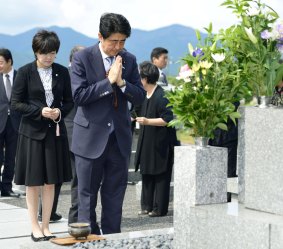 Mr Abe, accompanied by his wife Akie, prays at his ancestors' grave in Nagato, western Japan.