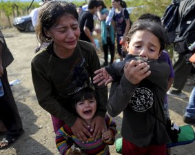 Girls cry as they get separated from their family at the border.