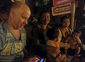 Michael Bachelard on a roadside in Kuta beach, Bali, interviewing street beggars.