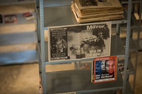 Kader Attia's <i>The Culture of Fear: An Invention of Evil</I> tall metal racks act as a showcase for books and periodicals.