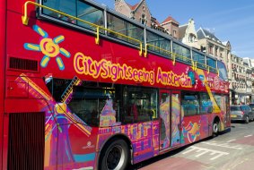 An Amsterdam sightseeing tourist bus with a panoramic roof offers tourists a hop-on, hop-off service at 12 points of interest.