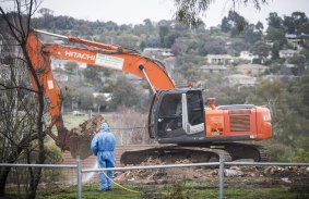 Workers demolish a Mr Fluffy house in Farrer.