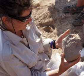 Archaeologist Sonia Harmand examines a stone tool she and a colleague found in Kenya.