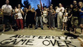 Supporters of the "OXI" or "No" vote stand by an anti-austerity banner as they celebrate results in Thessaloniki.