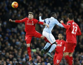 Aerial attempt: Liverpool's Alberto Moreno goes to head the ball with Manchester City's Bacary Sagna.