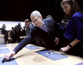Apple CEO Tim Cook reaches for an Apple Watch to show to model Christy Turlington Burns during the Apple event in San Francisco.