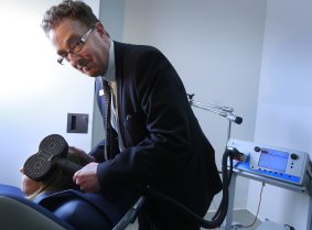 Dr Michael Gordon with a machine delivering magnetic therapy to a teenager's brain to try to treat depression.