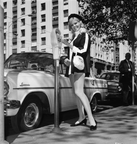 A 1960s meter maid feeds a parking meter in central Melbourne.
