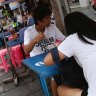 Lunch time: People eat noodles at a street food stall on Thonglor road, Bangkok, Thailand. Officials see street food as an illegal nuisance.