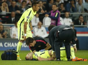 Barcelona's Andres Iniesta receives treatment before being substituted.