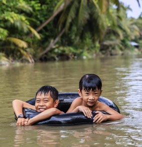 Vietnamese boys playing in the Mekong River Delta, Vietnam.