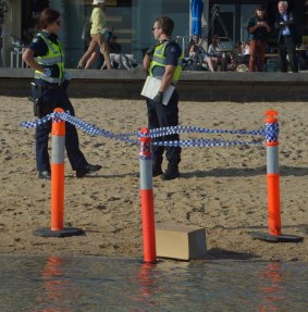 Police with the box of remains found on the St Kilda foreshore.