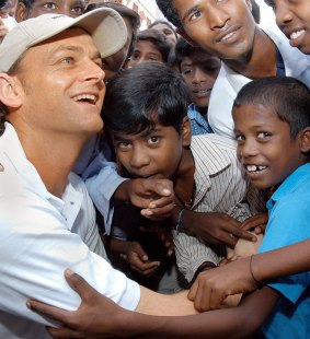 Former Australia captain Adam Gilchrist interacts with children during his visit to a slum in Madras October 12, 2004.