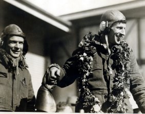 Charles Kingsford Smith, wearing a garland of roses, and Charles Ulm arrive at Brisbane in 1928.