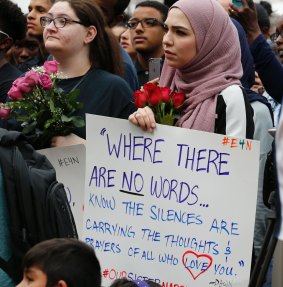 Mourners held signs and flowers as they listened to speakers at the vigil.