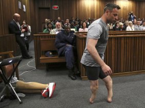 Oscar Pistorius' prosthetics lay on the floor as he walks on his amputated legs during argument in the High Court in Pretoria, South Africa. 