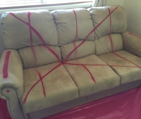 Red spray paint has been applied to a sofa in a Mr Fluffy house.