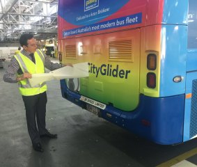 Brisbane City Council's public transport chairman Peter Matic puts the finishing touches on the new rainbow bus.
