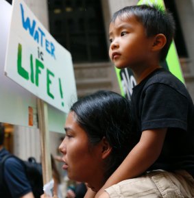 Mattea Twinn marches with her 3-year-old son, Khalil Khang in downtown Chicago in solidarity with the tribes fighting to stop the pipeline that would run from North Dakota to Illinois. 