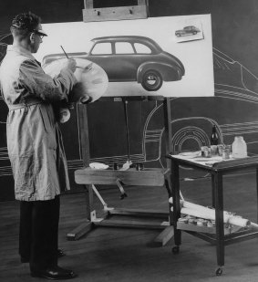 An artist in the Woodville Engineering Styling Studio working, with a blackboard tape outline of the 1942 Holden in the background.