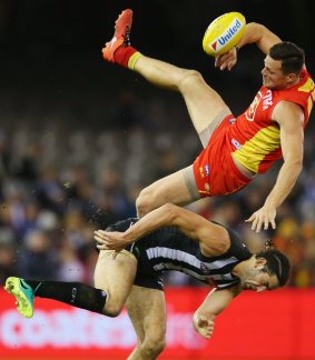 Big men collide: Steven May of the Suns and Brodie Grundy crash into one another going for a mark.