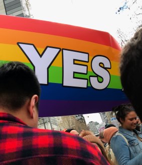 A rainbow-coloured 'Yes' flag flies at the Equal Love Rally in Melbourne's CBD.