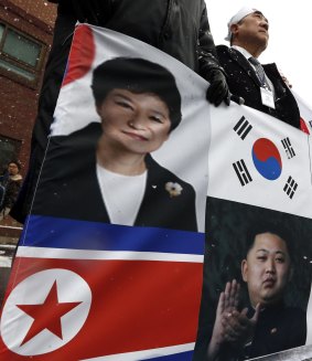 South Korean protesters hold a banner showing Ms Park and Kim Jong-un during a rally on Tuesday to support the Kaesong policy.