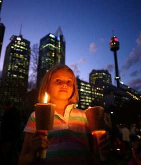 A girl holds candles in support of refugees in Sydney this week. Thousands of people around Australia gathered to remember Aylan Kurdi.