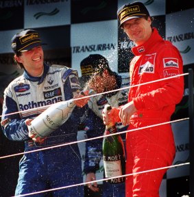 Winner of the 1996 Grand Prix, Damon Hill, sprays champagne on Eddie Irving. Both sport prominent cigarette advertising.