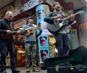 Greg Stone (far left), Keegan Joyce and Tom Parsons busk ahead of the opening of <i>Once</i> in 2014.