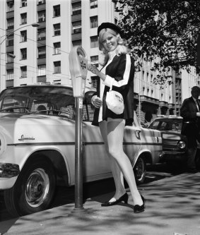 A 1960s meter maid feeds a parking meter in central Melbourne.