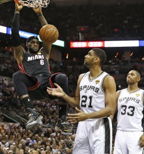 Miami Heat's forward LeBron James dunks the ball over the San Antonio Spurs' Tim Duncan.