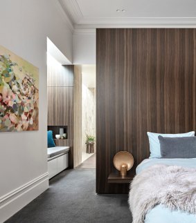 In this bedroom, the wardrobe has been concealed behind a dark-veneered timber blade wall. Photography by Peter Clarke; styling by Swee Lim.